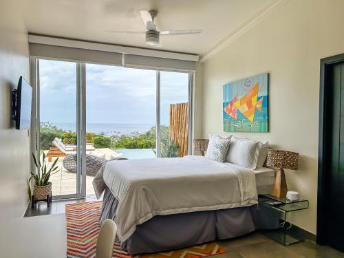 a bedroom with a bed and a large window at La Santa Maria Resort in San Juan del Sur