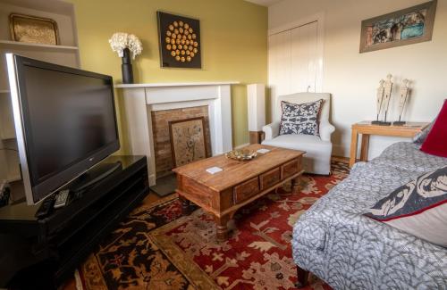 a living room with a flat screen tv and a couch at Foulis Castle Gate Lodge in Evanton