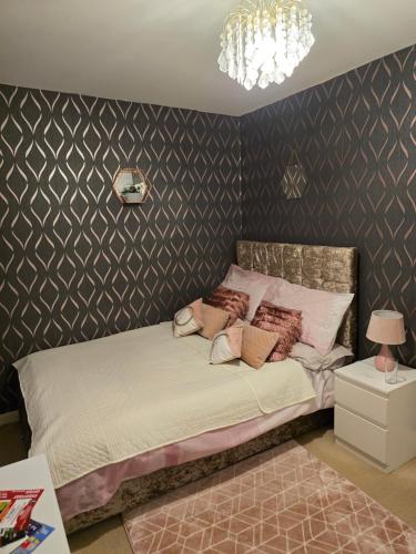 ein Schlafzimmer mit einem Bett und einem Kronleuchter in der Unterkunft Desborough home for short term rent in Desborough