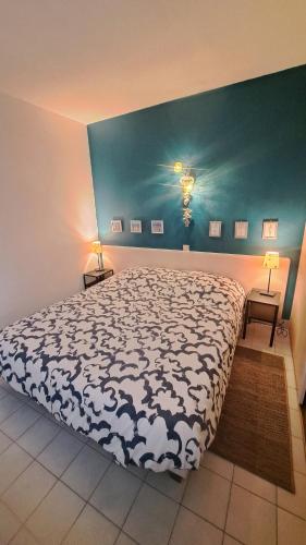 une chambre avec un lit avec une couette noire et blanche dans l'établissement PAMPLEMOUSSE 2 - Appartement avec piscine, vue mer, proche golf, à Saint-Jean-de-Monts