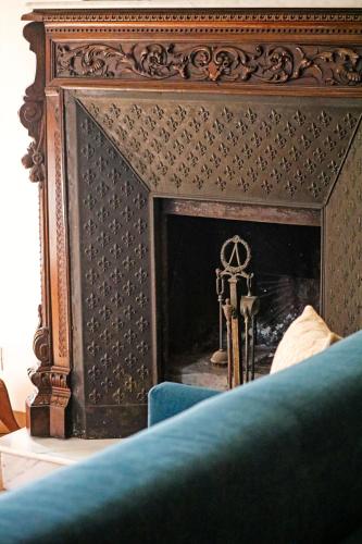 a fireplace with a wooden frame and a blue couch at Villa Margherita Art and Music in Marsala