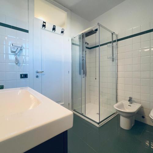 a bathroom with a shower and a sink and a toilet at Cas'Ale Suites Foresteria Lombarda in Crema