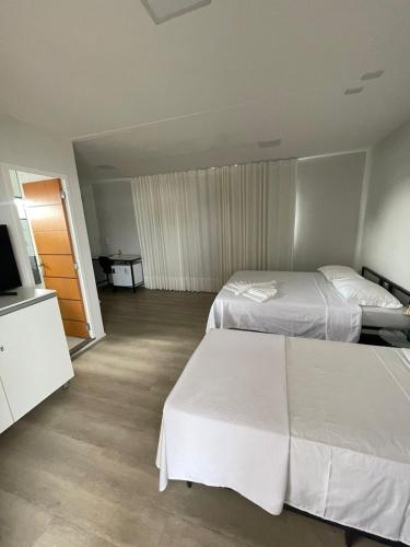 a hotel room with two beds and a flat screen tv at Aiezza Hotel in Barcarena
