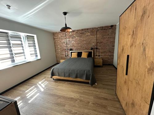 a bedroom with a brick wall and a bed at Apartament Stara cegła 1 i 2 in Głuszyca