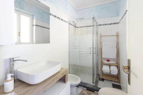 a white bathroom with a sink and a shower at La Veduta in Cannobio