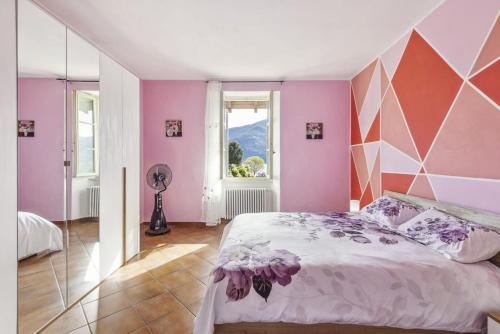 a bedroom with pink walls and a large bed at La Veduta in Cannobio