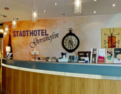 a restaurant counter with a clock on the wall at Arthotel ANA Petite in Gersthofen