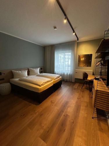 a bedroom with a bed and a desk in it at Arthotel ANA Petite in Gersthofen