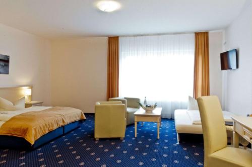 a hotel room with a bed and a living room at Arthotel ANA Petite in Gersthofen