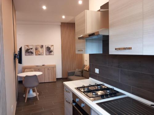 DONNA MELA apartments في بارشلونا-بوتسو دي غوتو: مطبخ مع موقد فرن علوي بجوار غرفة المعيشة