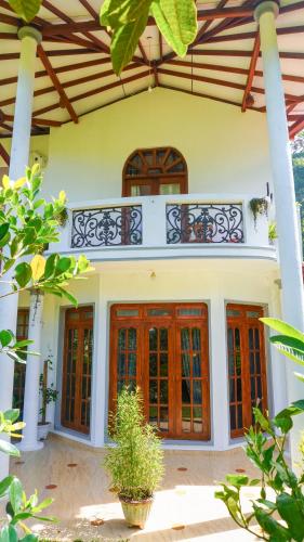 a house with red doors and a balcony at Bella Vista Ella in Ella