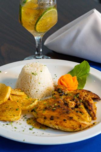a plate of food with rice and a drink at Grande Hotel da Barra in Salvador