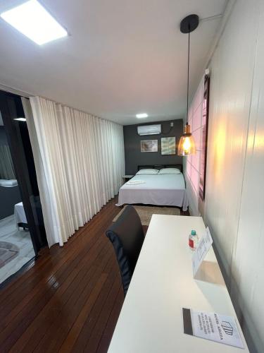 a small room with a bed and a desk and a table at Aiezza Hotel in Barcarena