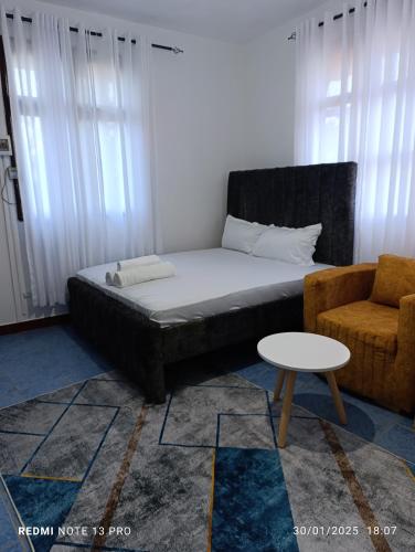 una camera da letto con un letto, un divano e un tavolo di Malaika Diani Homes a Ukunda