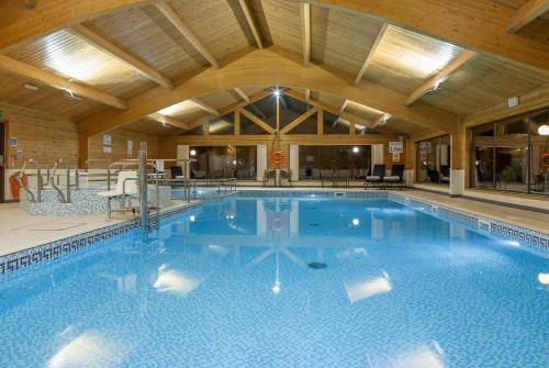 a large swimming pool in a large building at Sandmartin Lodge a lakeshore haven Pine Lake Resort in Carnforth