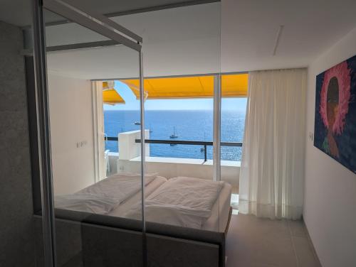 Un dormitorio con una cama con vista al mar. en Sonido del mar Gran Canaria - Montemarina - luxury panoramic view, en Mogán