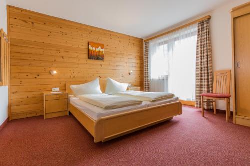 a bedroom with a bed and a wooden wall at Haus Waltraud in Neustift im Stubaital