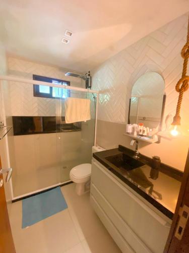a bathroom with a shower and a toilet and a sink at Quarto e sala com piscina em Maceió - Villas Tulipa 02 in Maceió