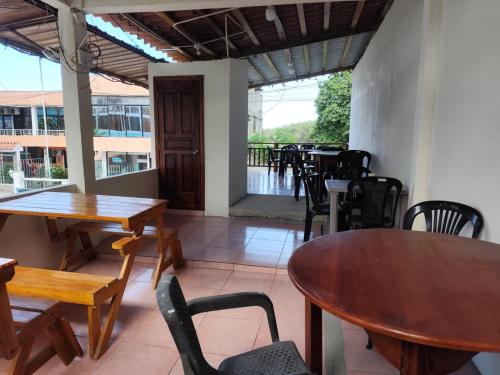 an empty restaurant with tables and chairs and a patio at Hotel South Beach Atacames in Atacames
