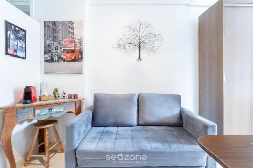 a blue couch in a living room with a table at Lindo Condomínio com Lazer em Poços de Caldas - QUI in Poços de Caldas