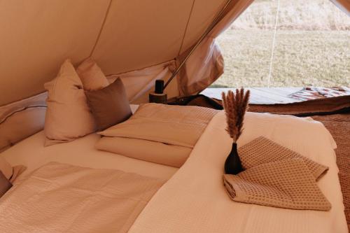 a bed in a tent with two pillows at Boho Zelt Lebenshofalpakas in Ziemetshausen