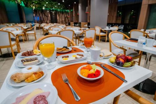 a table with breakfast foods and drinks on it at Holiday Inn Rosario by IHG in Rosario