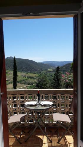Una mesa y sillas en un balcón con vista. en Vue D Ansignan, en Ansignan