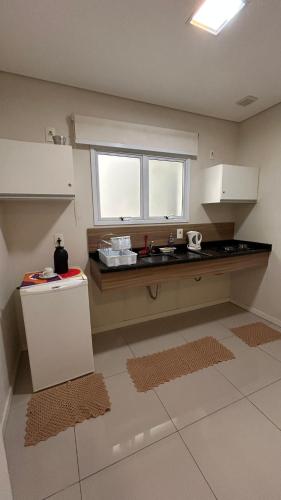 a kitchen with a sink and a counter top at Apto Top Centrum Holambra/excelente localização in Holambra
