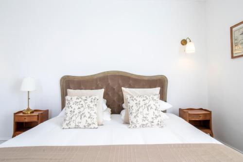 a bedroom with a white bed with white pillows at Domaine de Bonaveau - Spa & Piscine in Barcelonne