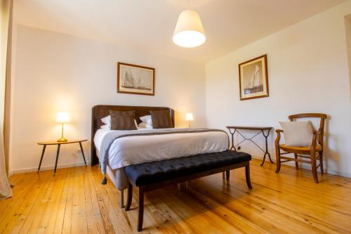 a bedroom with a bed and two chairs at Domaine de Bonaveau - Spa & Piscine in Barcelonne