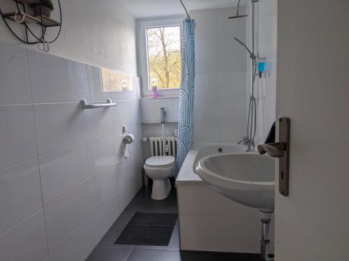a bathroom with a sink and a toilet and a window at Monteurwohnung Ferienwohnung Business Appartement Velbert 6 Personen in Velbert