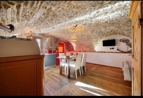 a kitchen and dining room with a brick wall at La Cachette Relax CIR 0001 in Aosta
