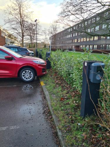 a red car parked next to a parking meter at Bayer Apartments Copenhagen in Tåstrup