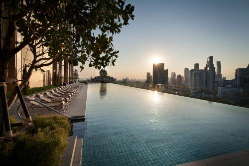 a large swimming pool on the roof of a building at Grande Centre Point Lumphini Bangkok in Bangkok