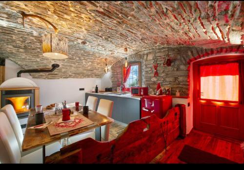 a kitchen with a table and a red door in a room at La Cachette Relax CIR 0001 in Aosta