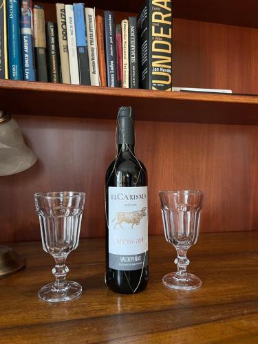 a bottle of wine and two glasses on a shelf at U Pešků in Kožlí u Orlíka