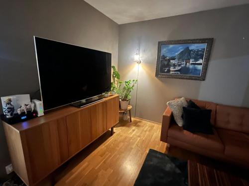ein Wohnzimmer mit einem großen Flachbildfernseher in der Unterkunft Spacious 3 bed terraced house in Trondheim