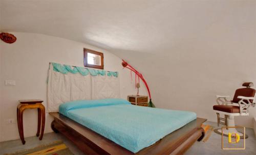 a bedroom with a bed with blue sheets in it at Dammusi Ambra in Pantelleria