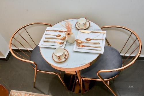 una mesa blanca con sillas, platos y tazas. en ARA chic studio Bali Douala, en Douala