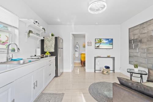 a kitchen with a sink and a living room with a couch at Cozy Casarita Cottage in Miami