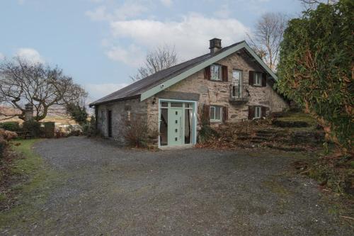 an old stone house with a green door at Morfa Lodge in Porthmadog