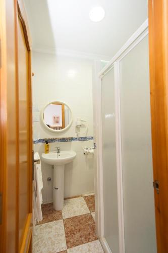 a white bathroom with a sink and a mirror at Apartamentos El Palmeral in Conil de la Frontera