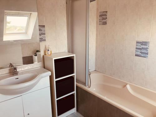 un baño con lavabo y bañera en La Taverne Bretonne, en Renac