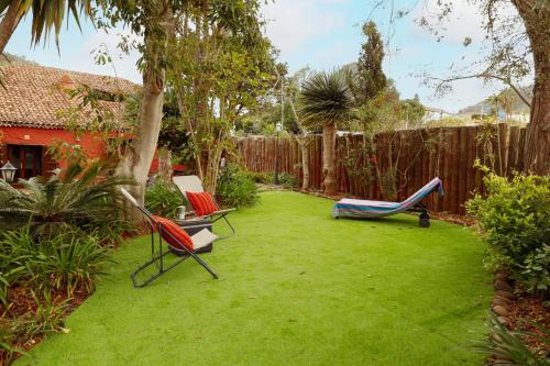 a yard with two lawn chairs and a fence at Masoala in Tacoronte
