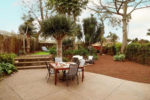 a table and chairs in a garden with palm trees at Masoala in Tacoronte