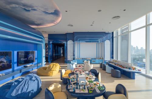 a living room with blue walls and a table and chairs at Grande Centre Point Lumphini Bangkok in Bangkok