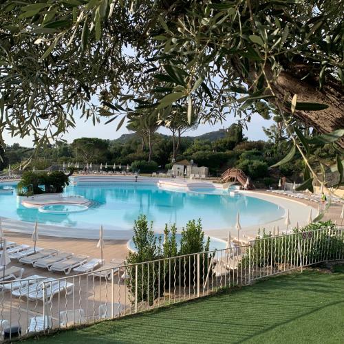 une grande piscine avec des chaises et une clôture dans l'établissement Superbe T2 club cap Estérel Animations petits et Grands sports&Activités MULTISPORTS, à Saint-Raphaël