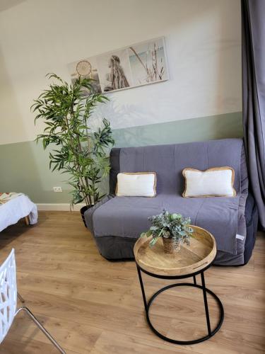 un salon avec un canapé bleu et une table dans l'établissement Studio bord de mer - Plage - Piscine - Wifi, à Santa-Lucia-di-Moriani