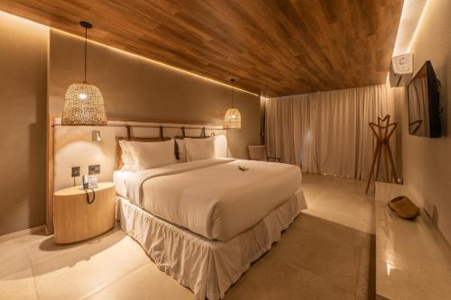 a bedroom with a large bed and a wooden ceiling at Hamares Boutique Hotel in Fernando de Noronha