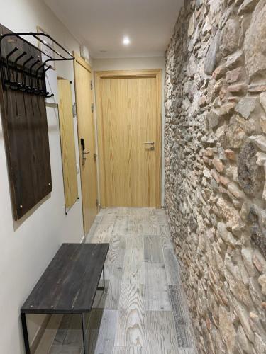 a room with a stone wall and a wooden door at Hostal Milana Girona in Girona